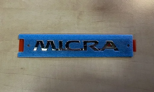 Nissan Micra (4/17-) (K14FR) embleem tekst ''Micra'' achterzijde Origineel! 908925FA0A RESTPARTIJ!